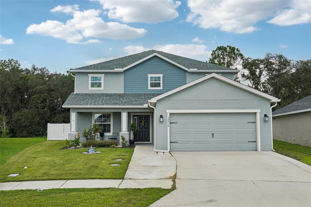 a front view of a house with a yard and garage