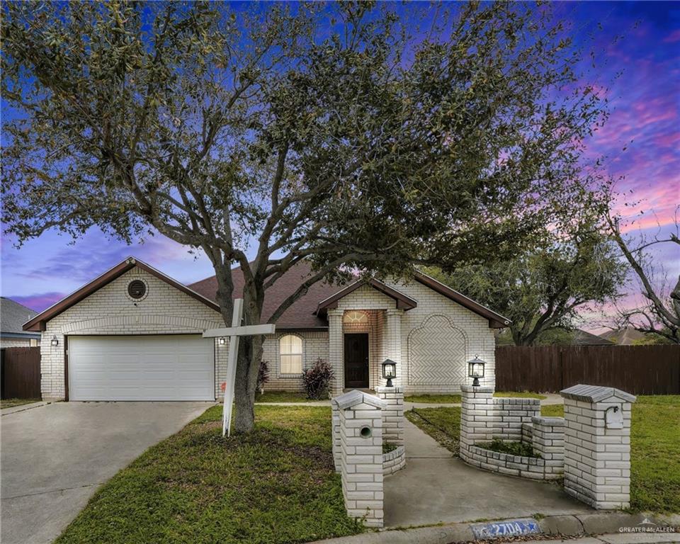 Single story home with a garage and a lawn