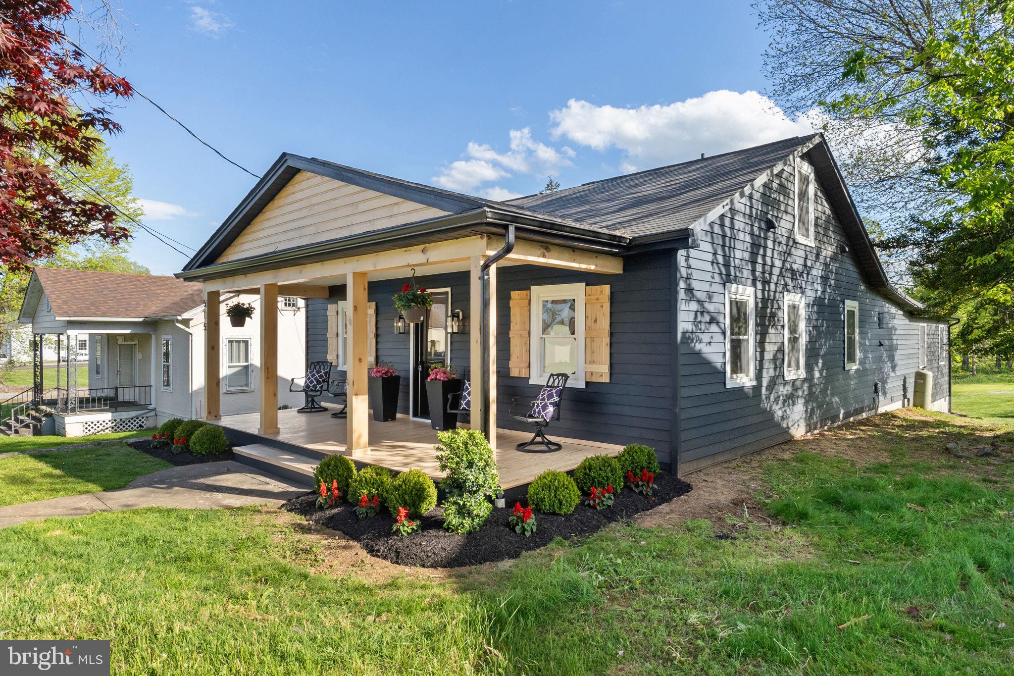 a front view of a house with porch and garden