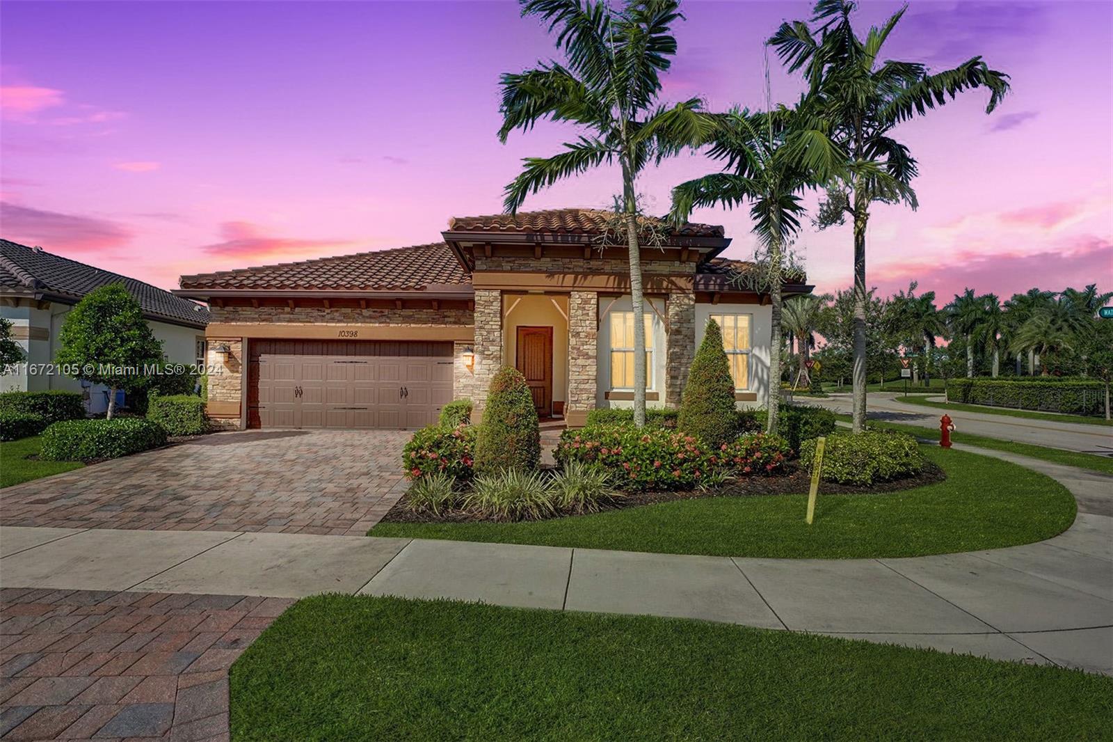 a front view of a house with a garden and yard