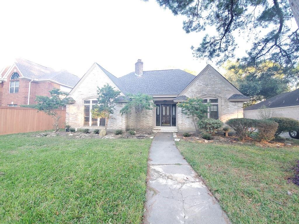 a front view of a house with a yard and trees