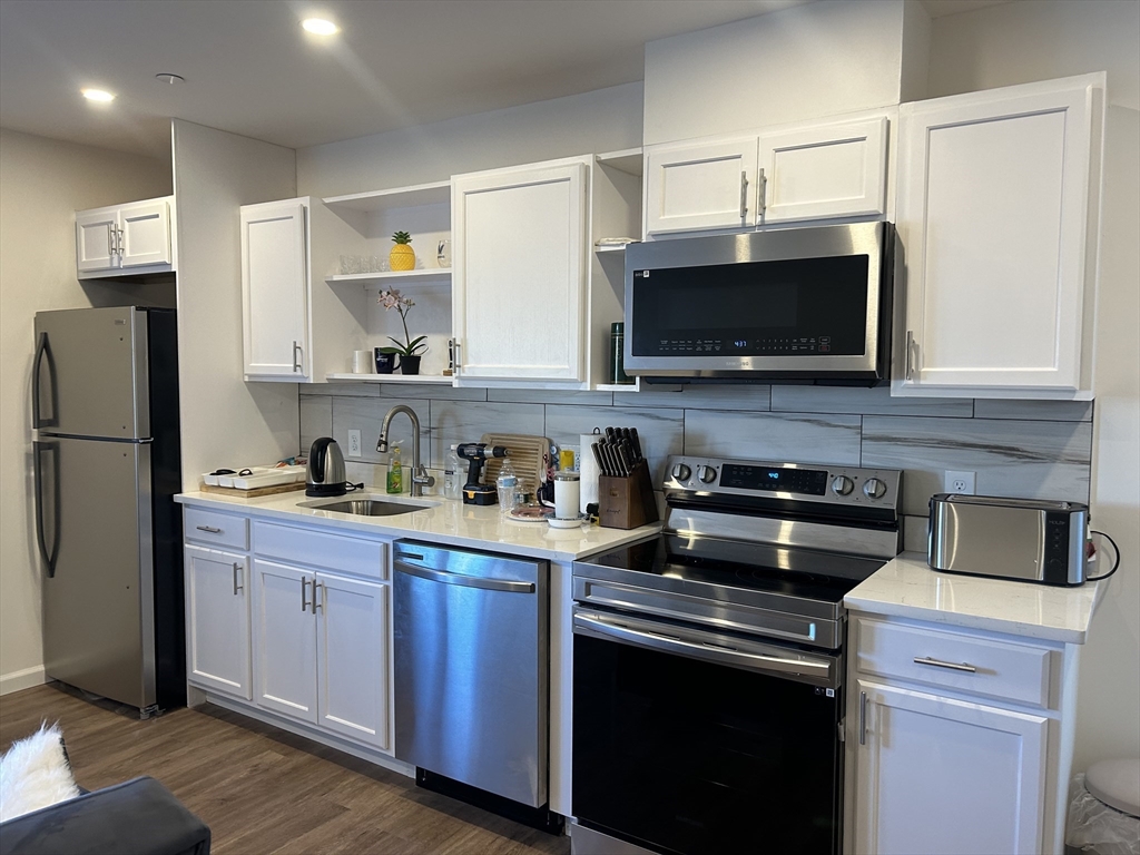 a kitchen with stainless steel appliances a stove sink microwave and refrigerator