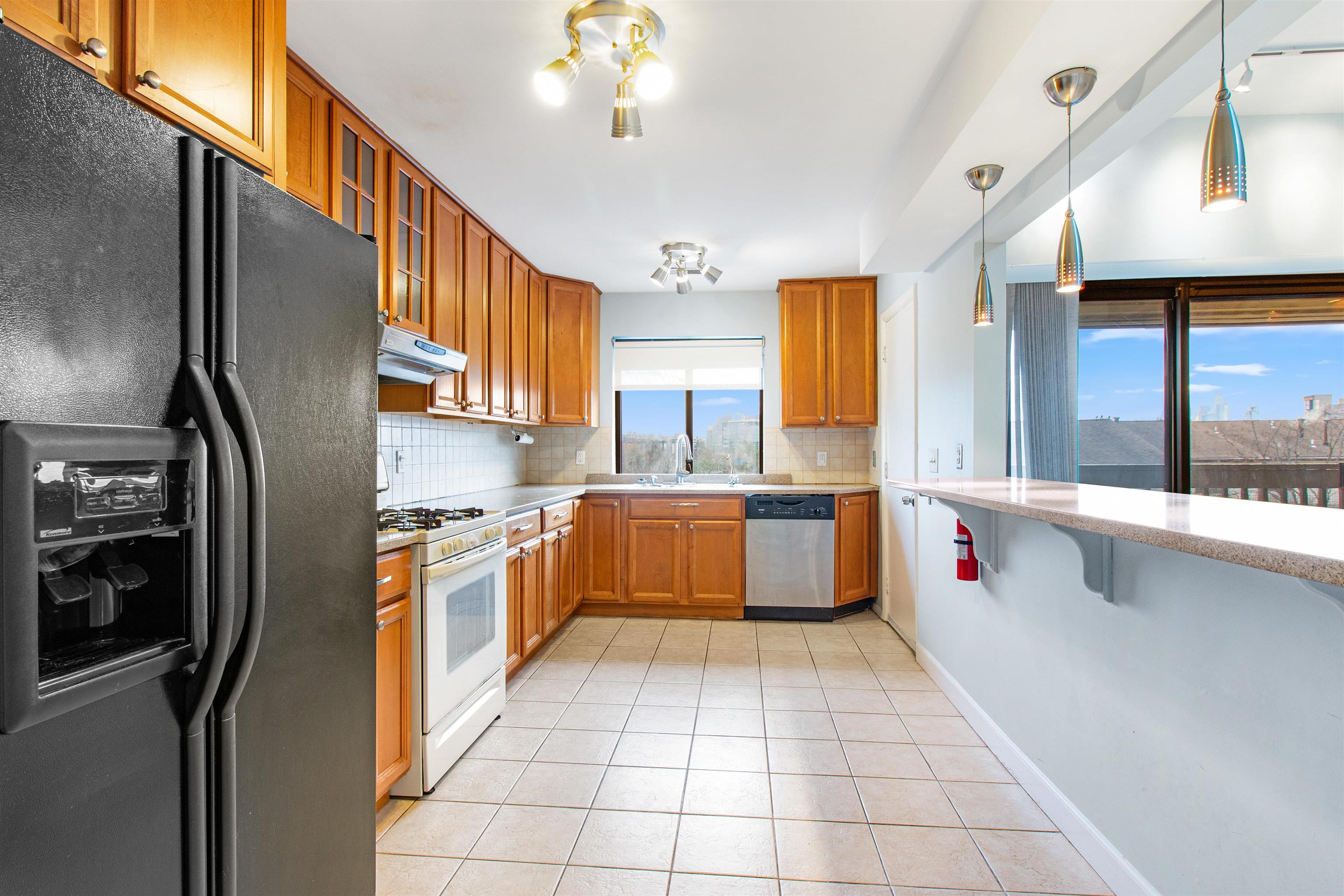 a kitchen with stainless steel appliances granite countertop a refrigerator and a sink