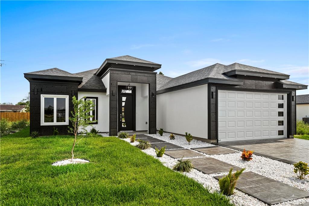 Prairie-style house featuring a garage and a front yard