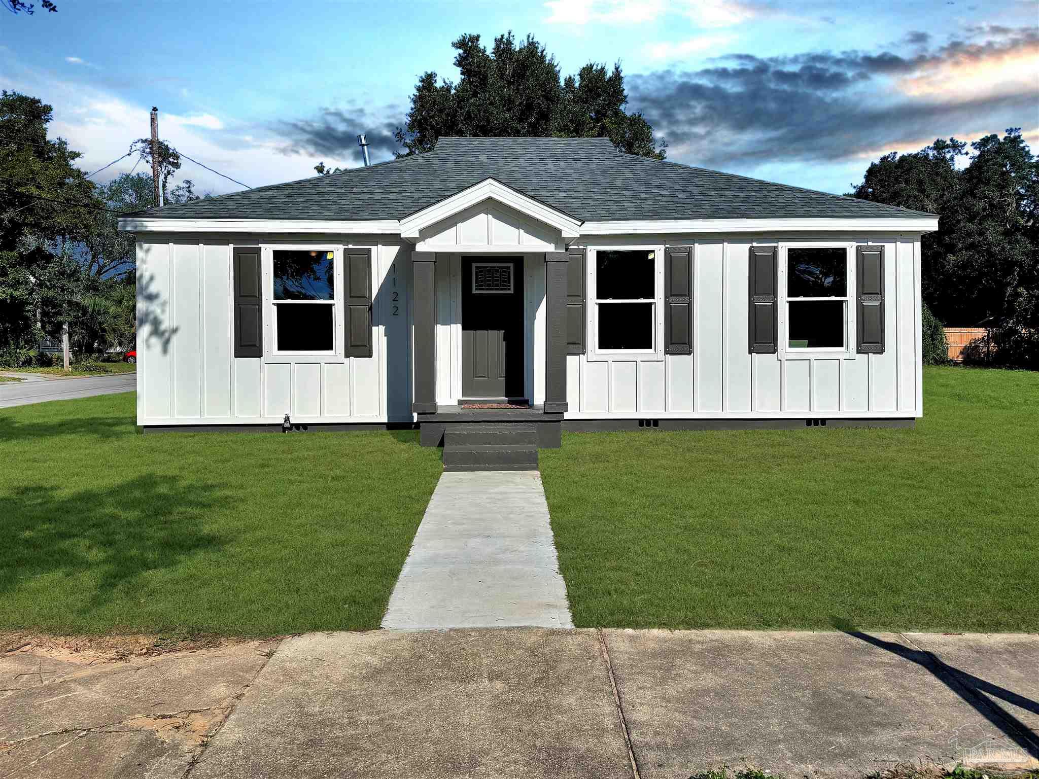 a front view of a house with a garden