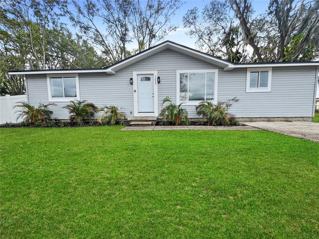 a front view of a house with a garden and yard