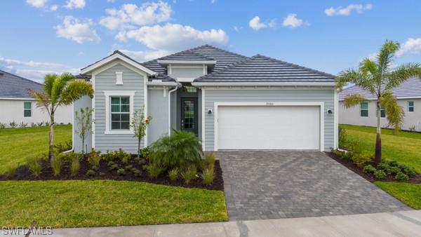 View of front of property featuring a front lawn and a garage