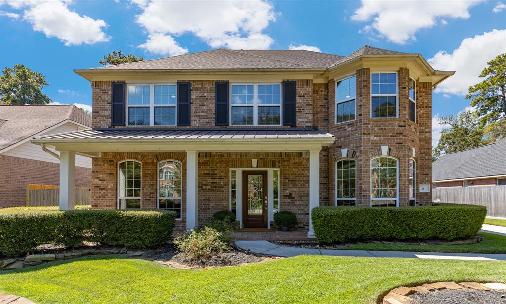 front view of a brick house with a yard