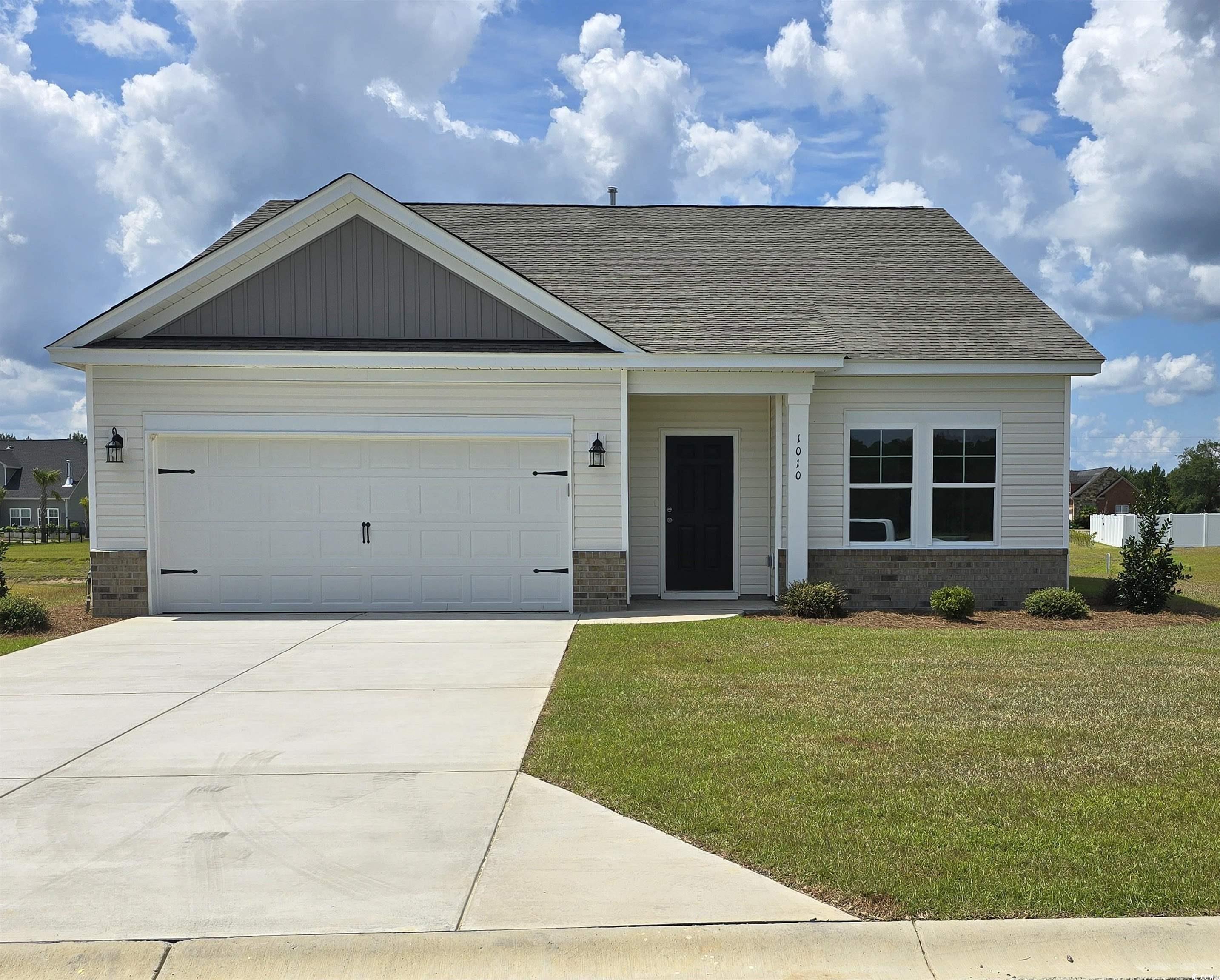 View of front of home with a garage and a front ya