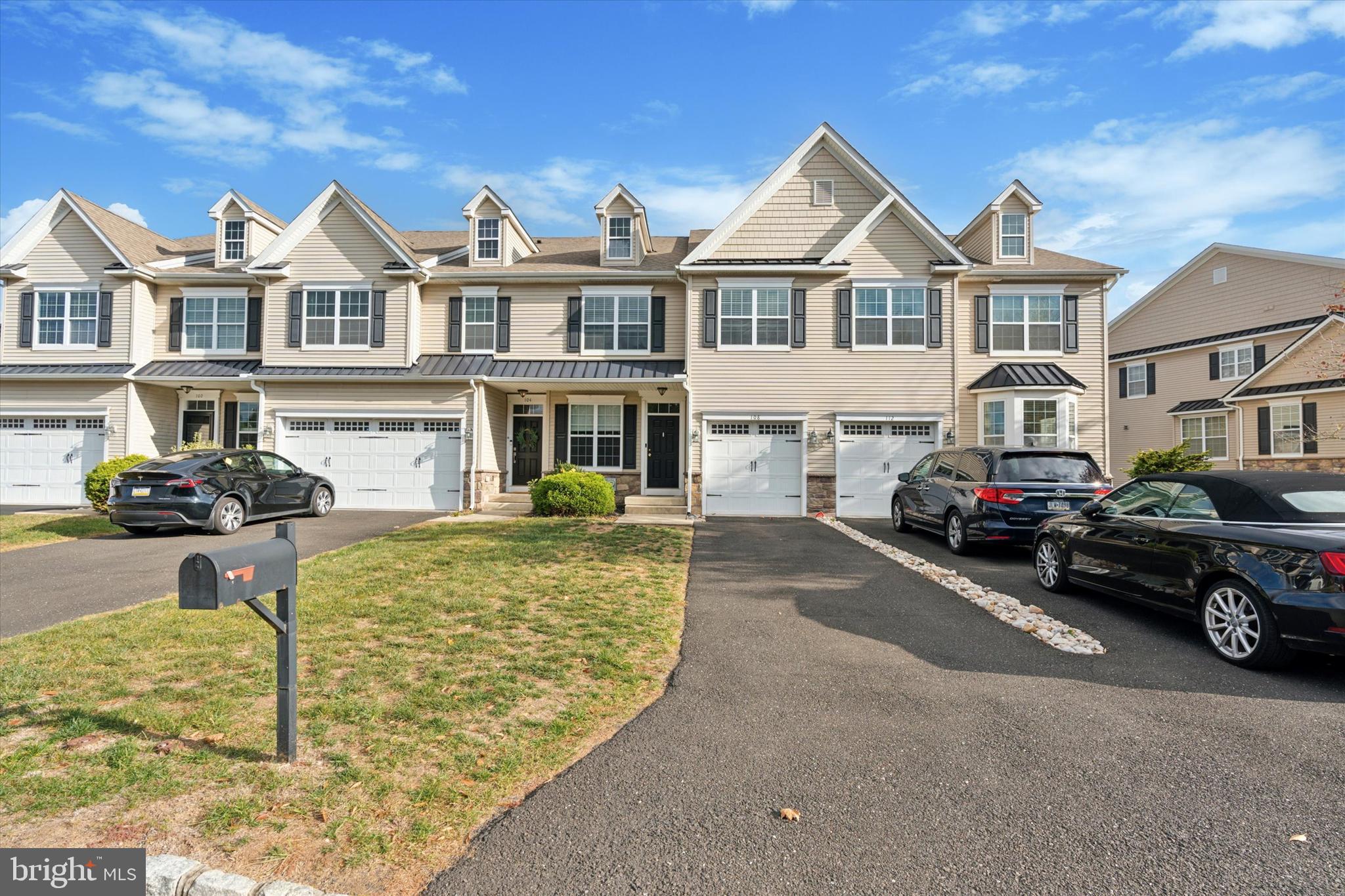 a front view of a house with cars parked