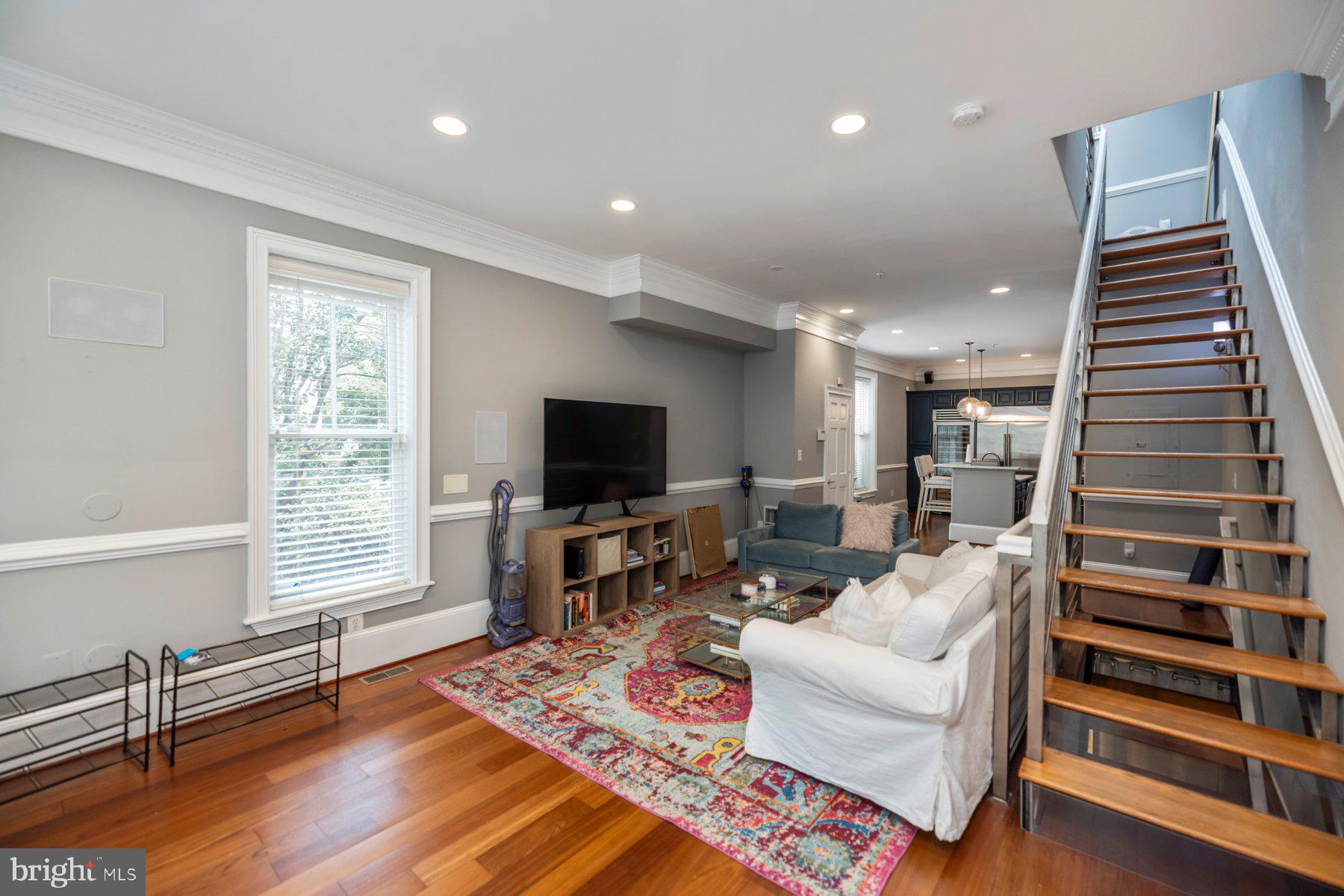 a living room with furniture a flat screen tv and wooden floor