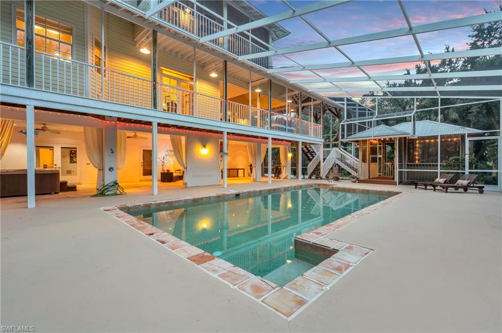 Pool at dusk featuring a patio and screened enclosure