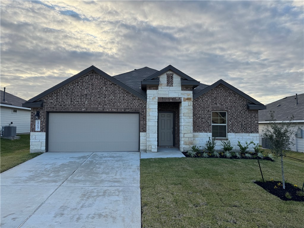 View of front of home with a front lawn, a garage,