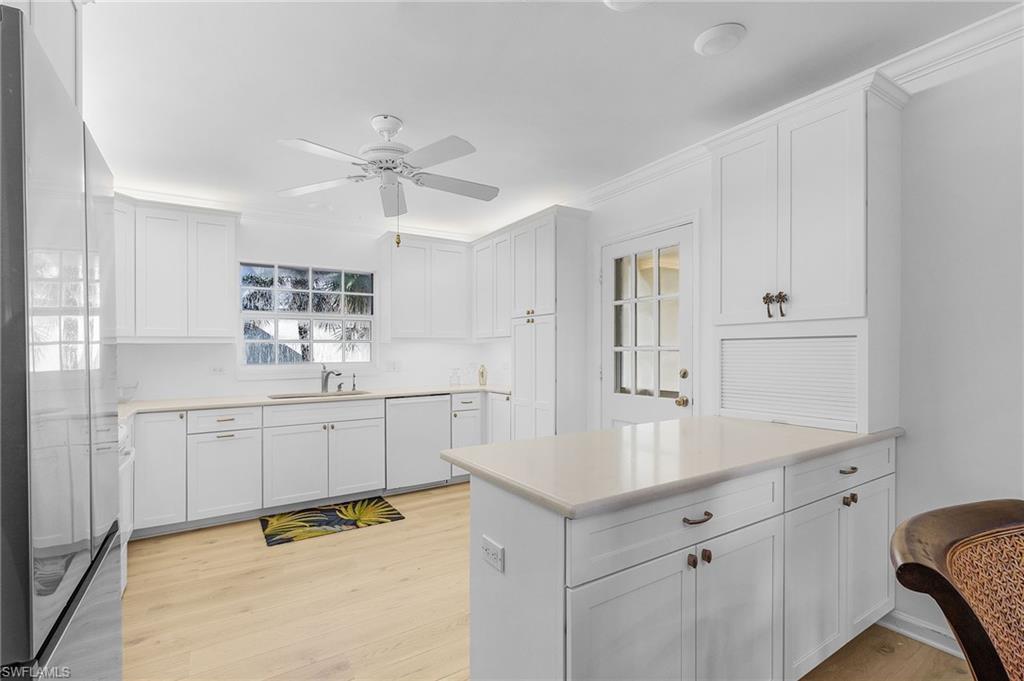 a kitchen with white cabinets and sink