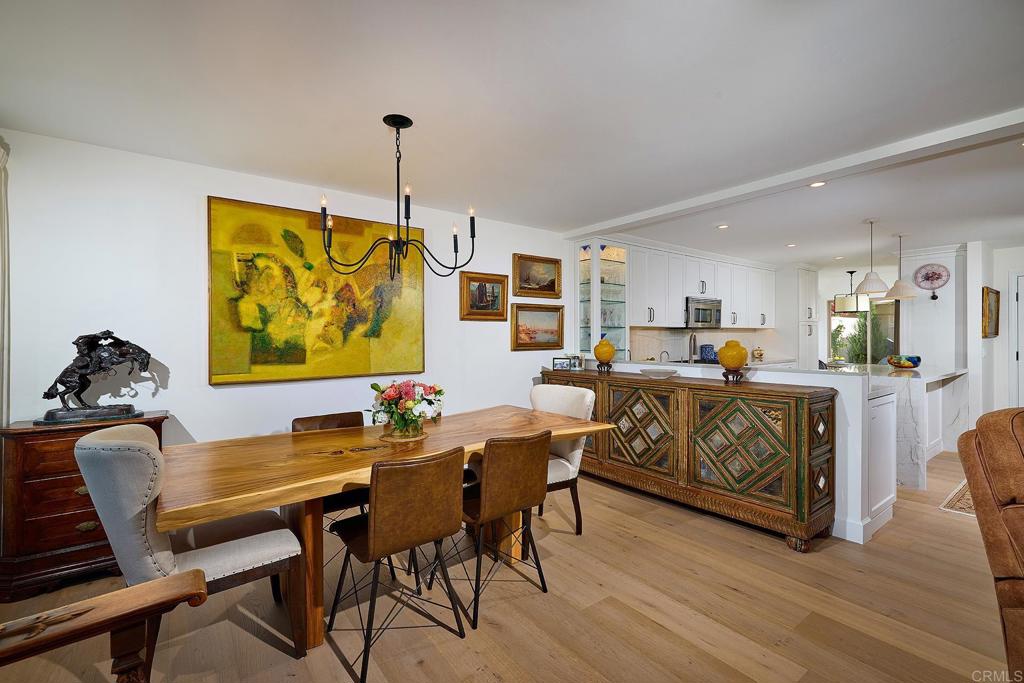 a living room with furniture kitchen view and a wooden floor