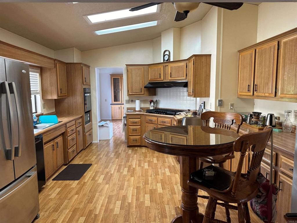 a kitchen with kitchen island granite countertop a sink a counter space appliances and cabinets