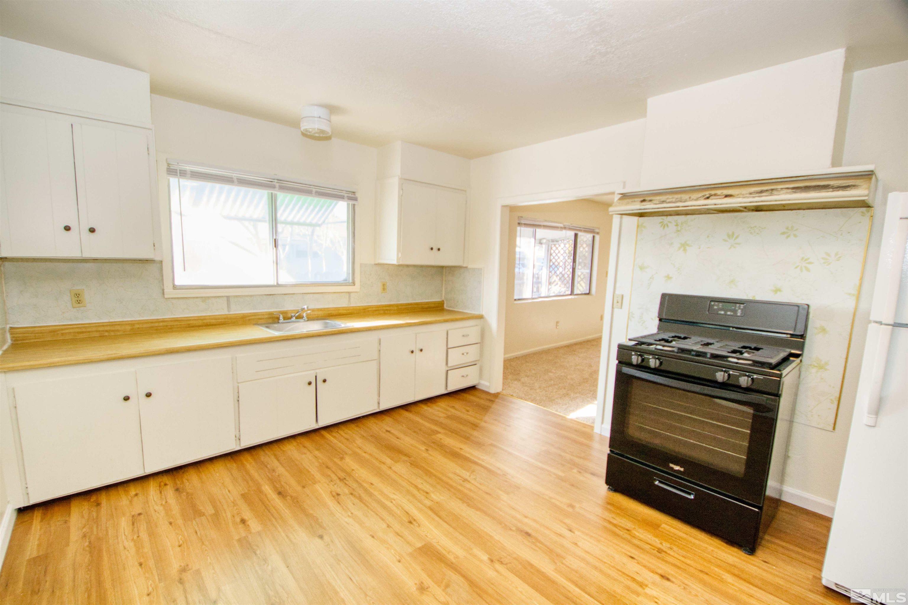 a kitchen with stainless steel appliances a stove a sink and white cabinets