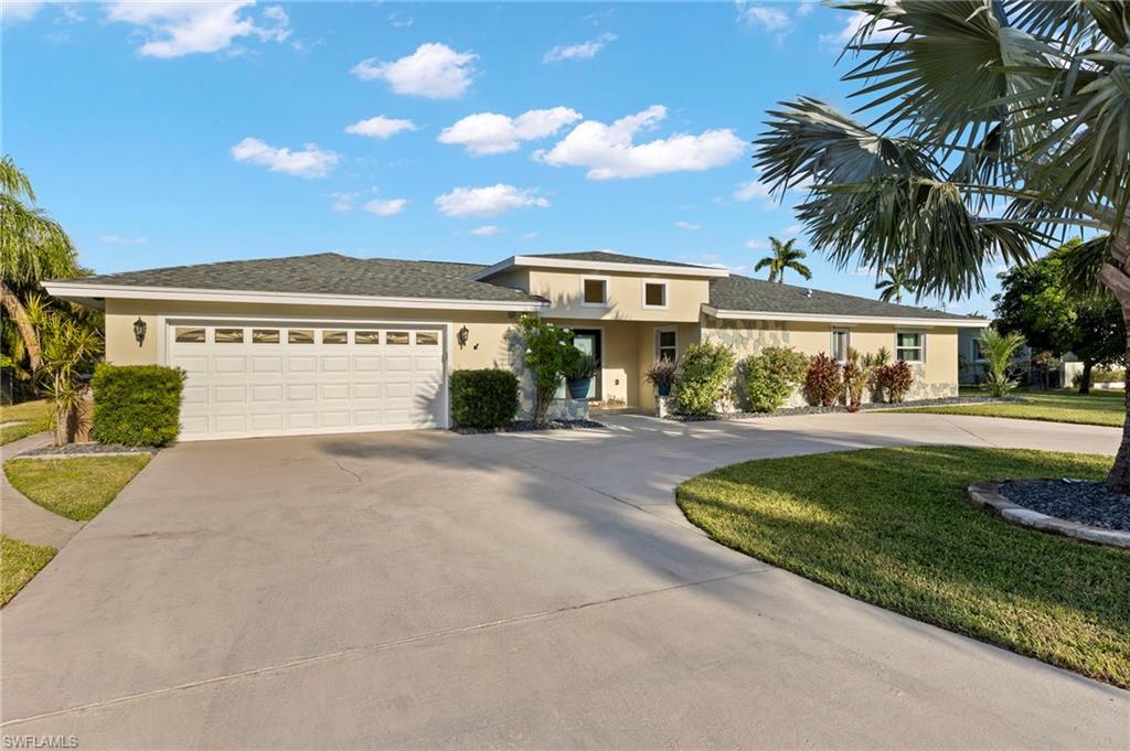 a front view of a house with a yard and palm tree