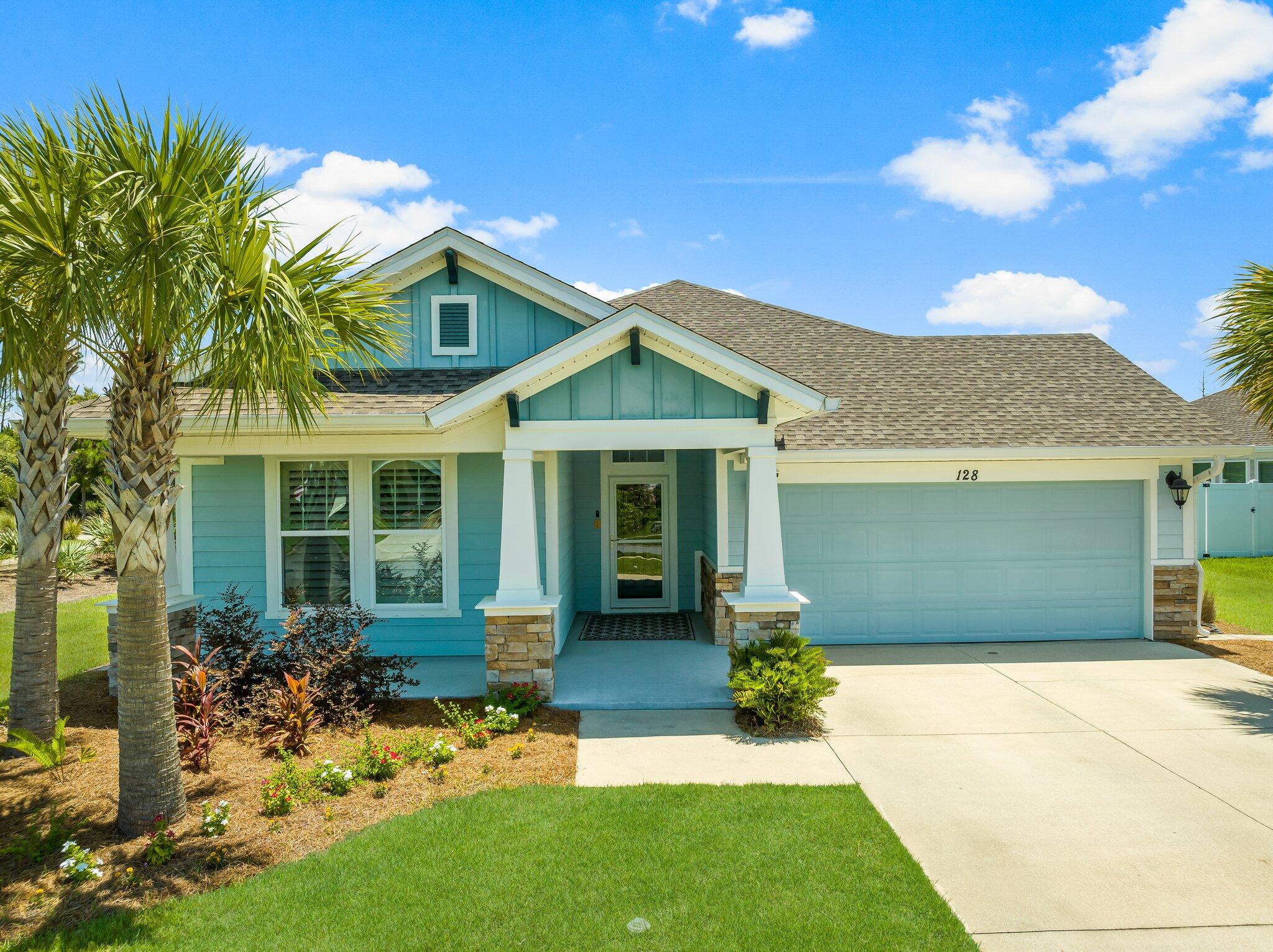 a front view of a house with a garden and yard