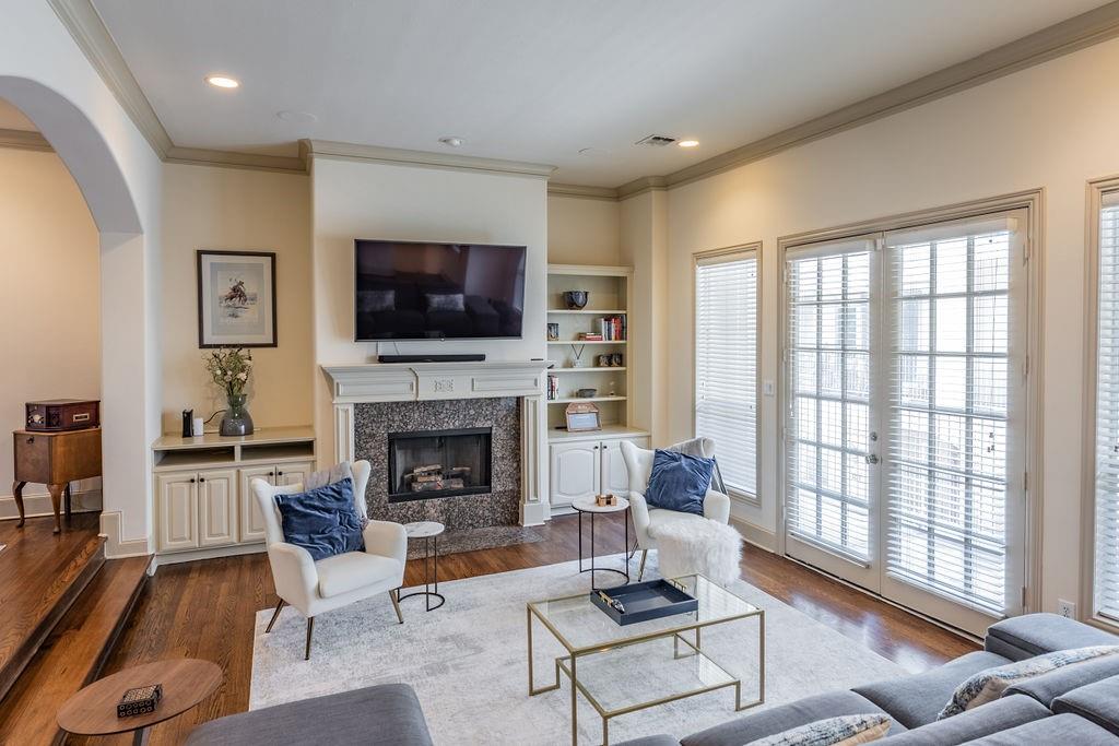 a living room with furniture a flat screen tv and a fireplace