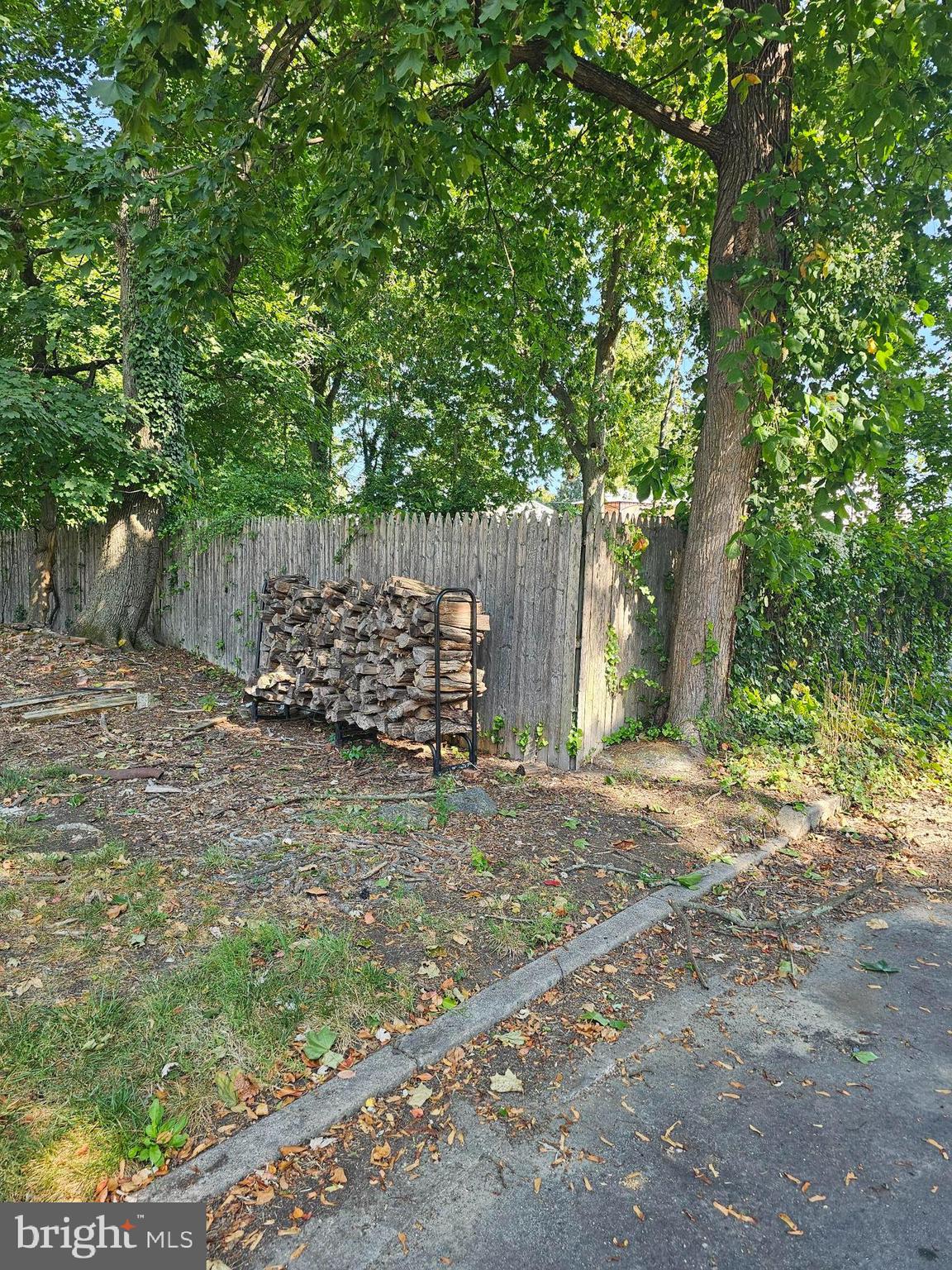 a view of a yard with wooden fence