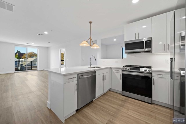 a kitchen with a sink and steel appliances