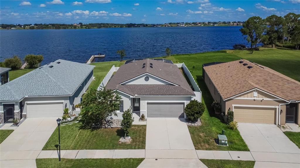 an aerial view of a house with outdoor space and lake view