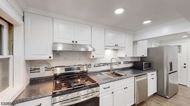 a kitchen with stainless steel appliances a stove a sink a refrigerator and cabinets