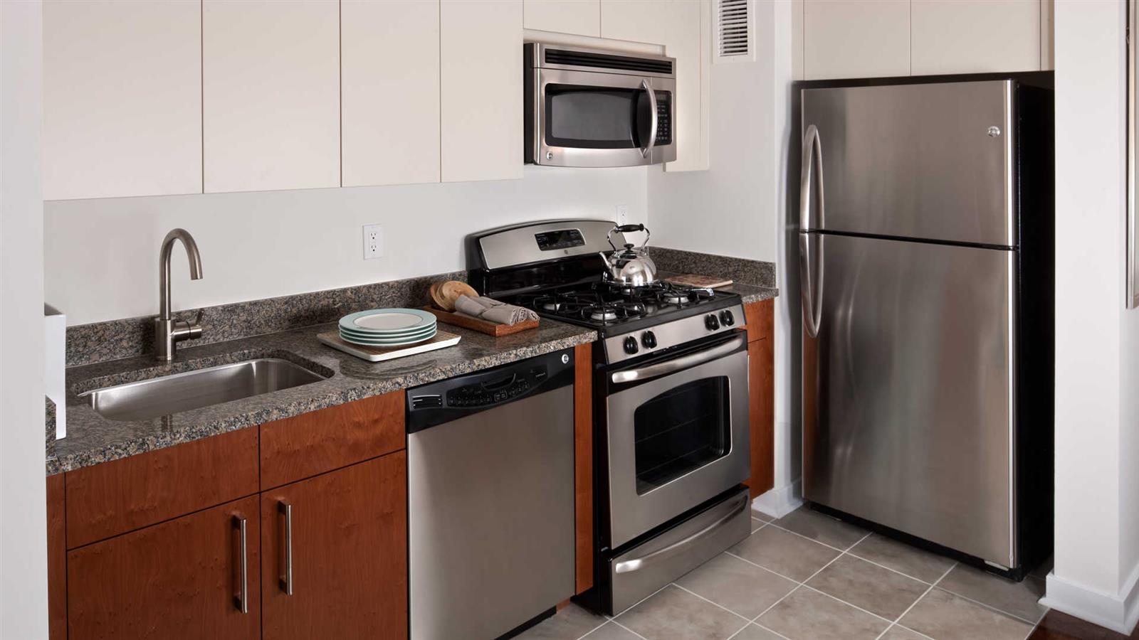 a kitchen with granite countertop stainless steel appliances and wooden cabinets