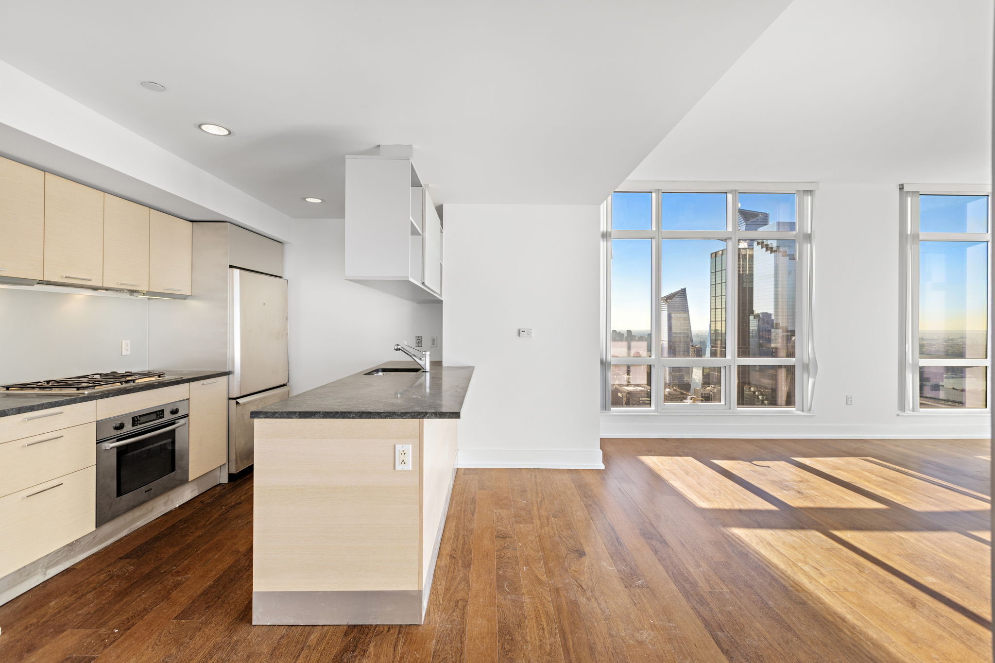 a kitchen with granite countertop a stove a sink and a refrigerator