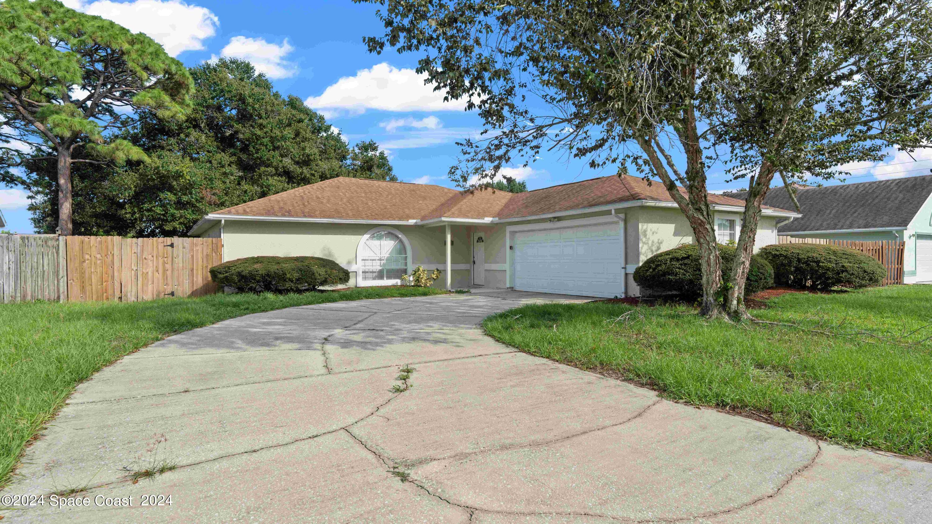 a front view of a house with a yard and trees