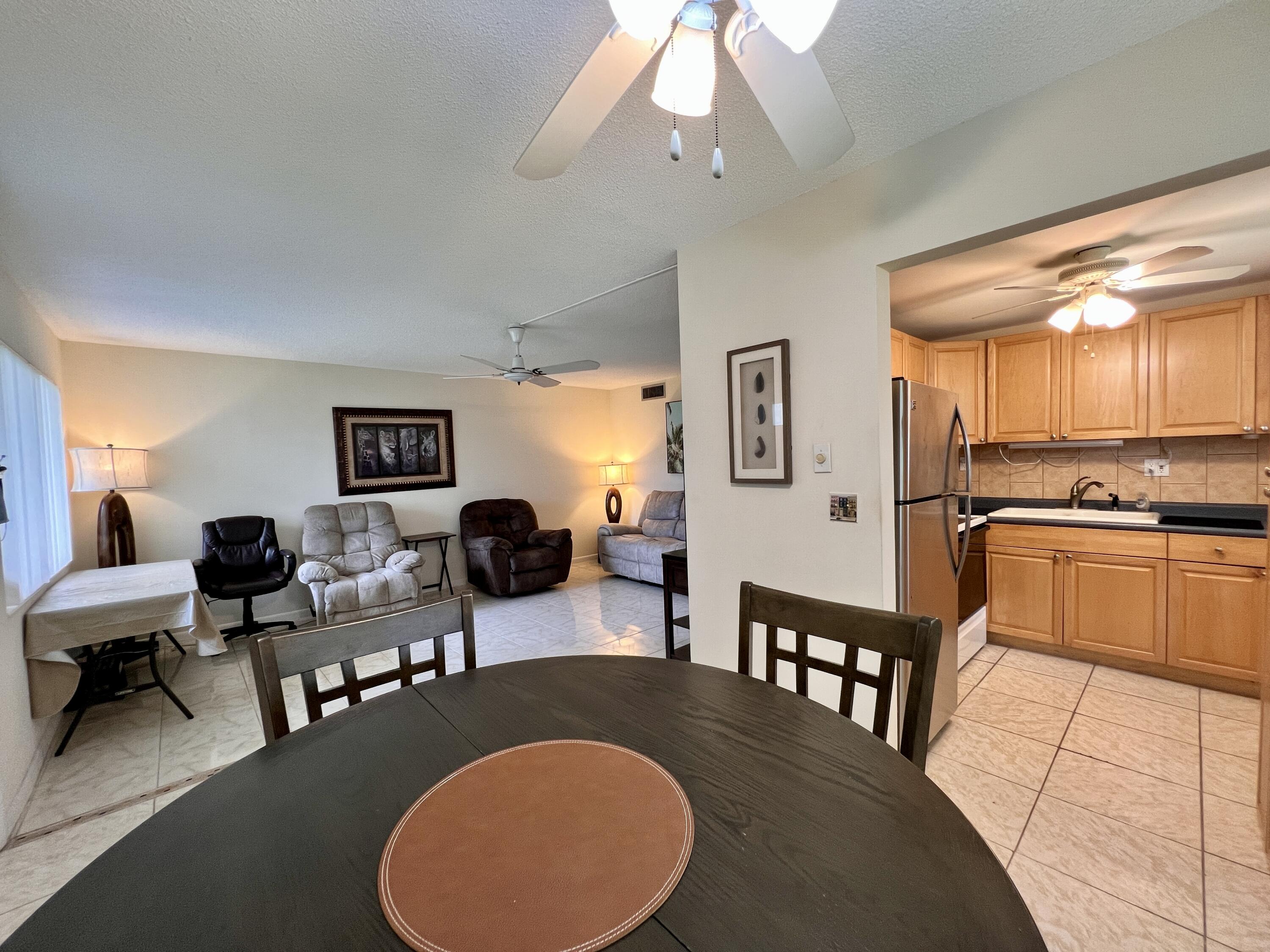 a living room with furniture a flat screen tv and kitchen view