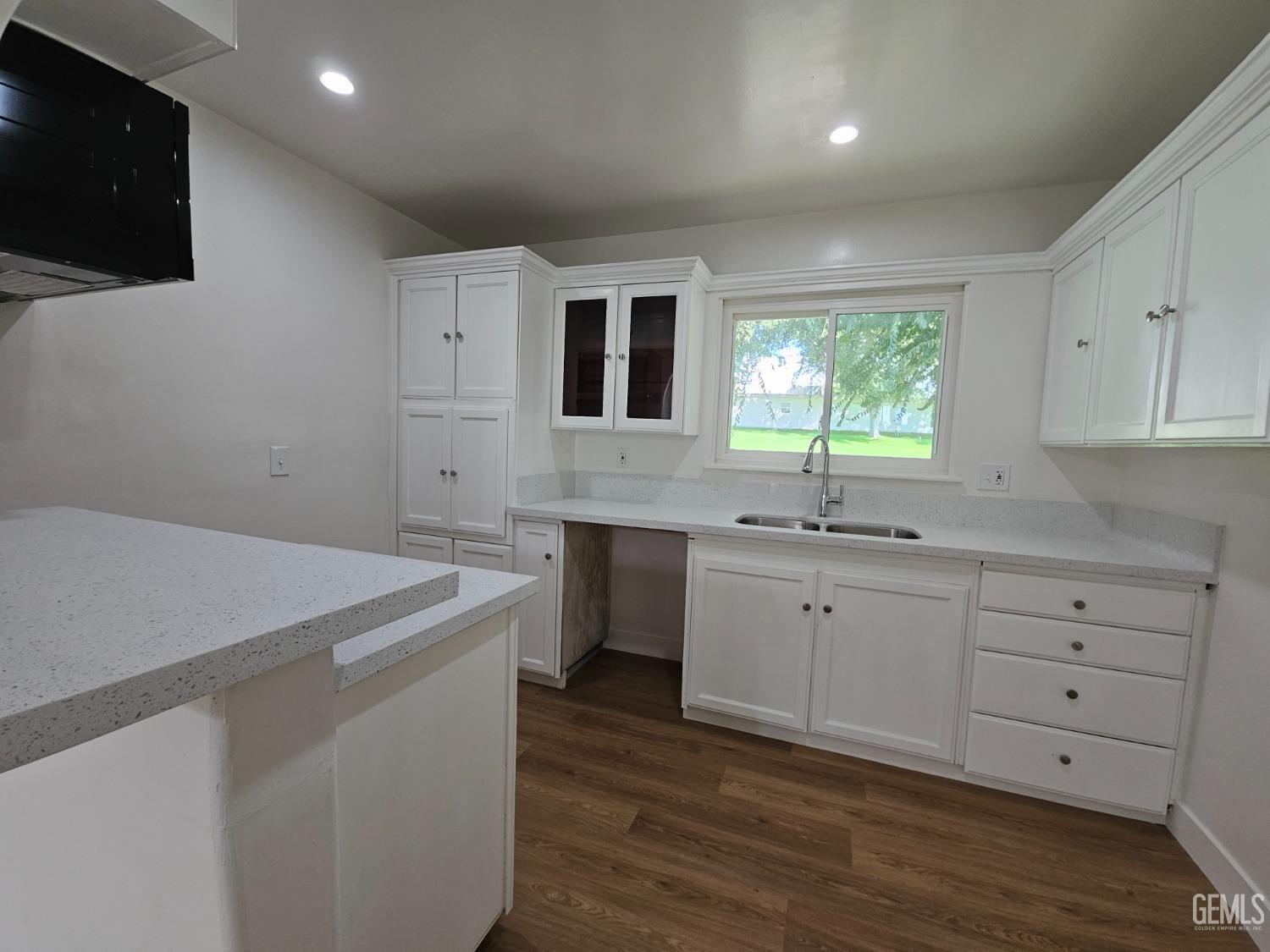 a kitchen with sink cabinets and wooden floor