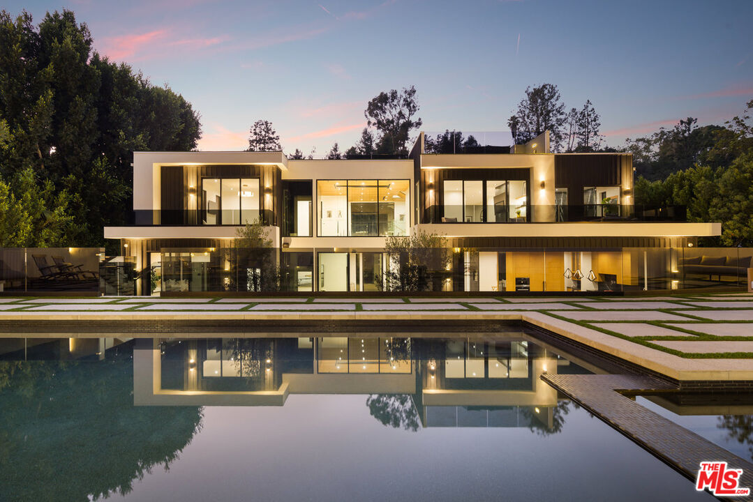 a front view of a house with swimming pool and sitting area