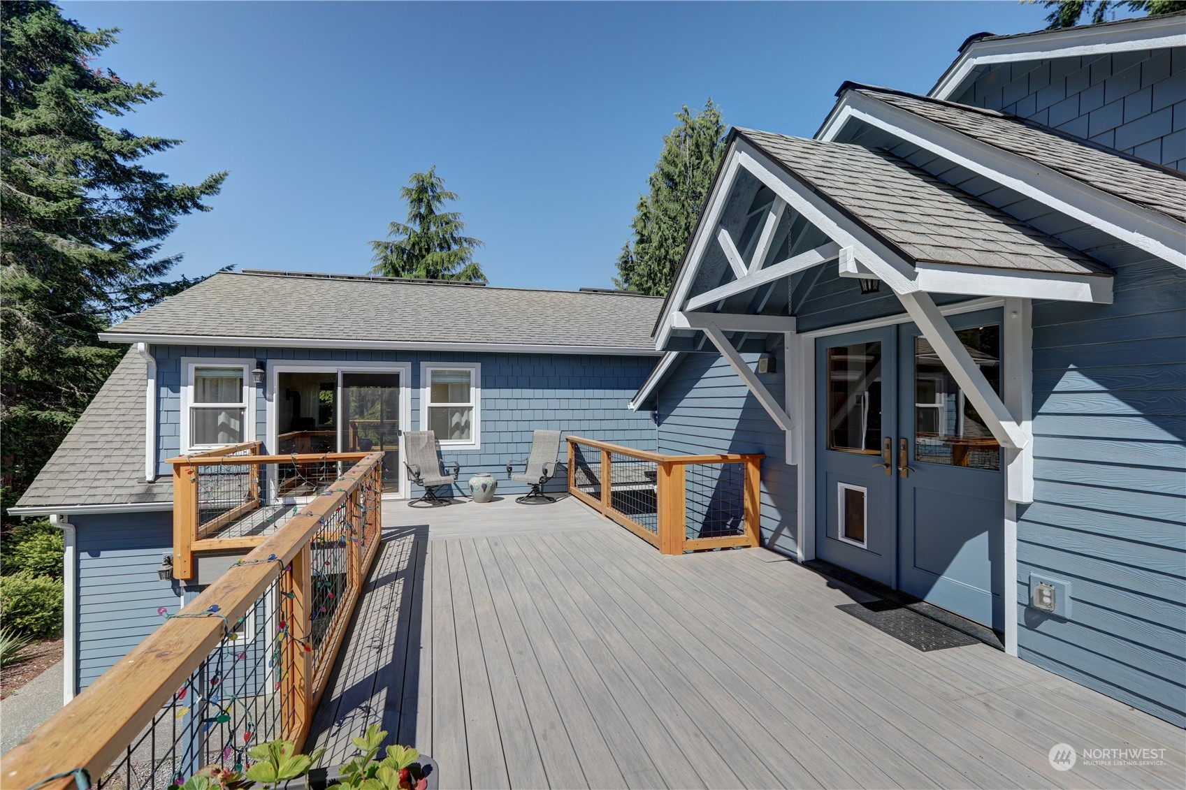 a view of a house with wooden deck and furniture