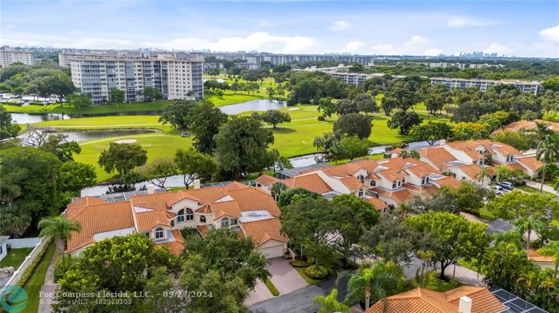 an aerial view of a city with lots of residential buildings ocean and mountain view in back