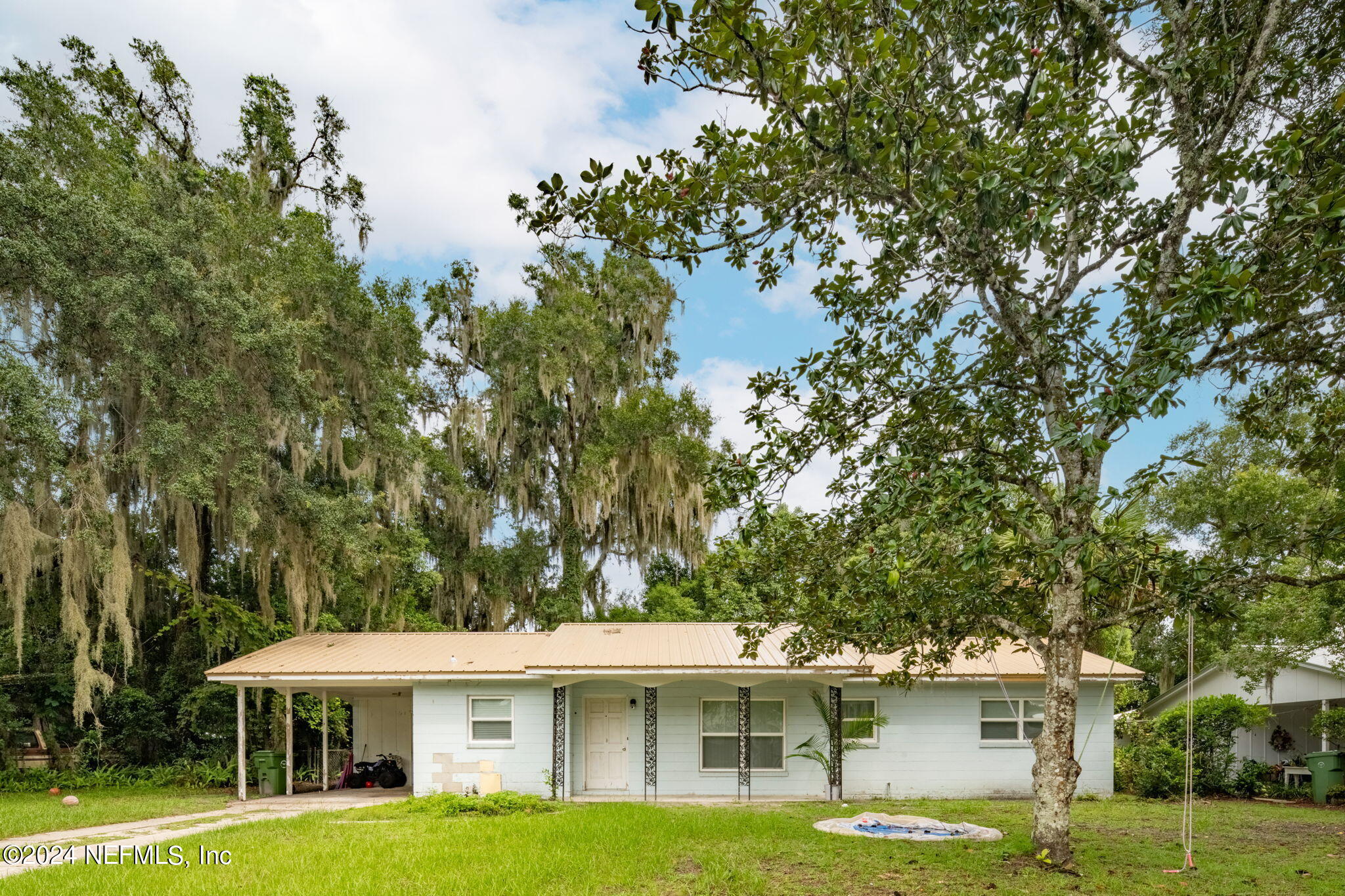 a front view of a house with a garden and trees