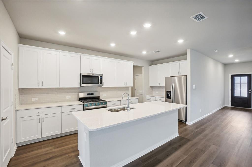 a kitchen with stainless steel appliances a refrigerator sink and microwave