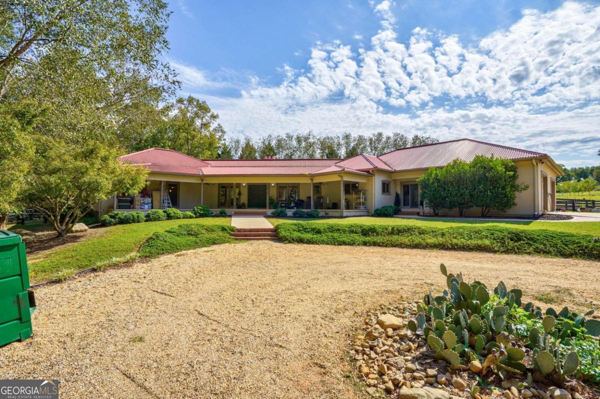 a front view of house with yard and trees in the background