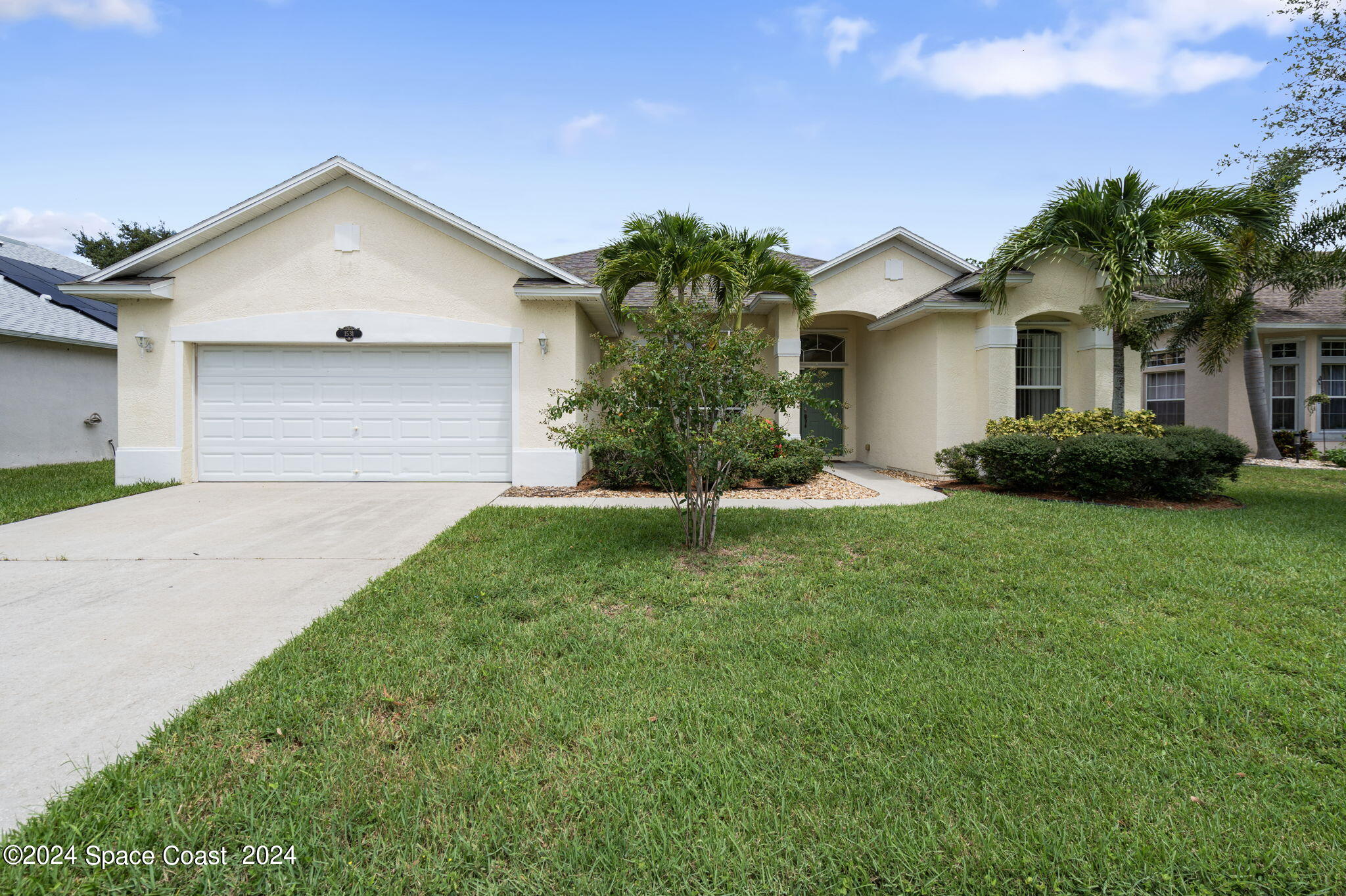 a front view of a house with a yard and garage