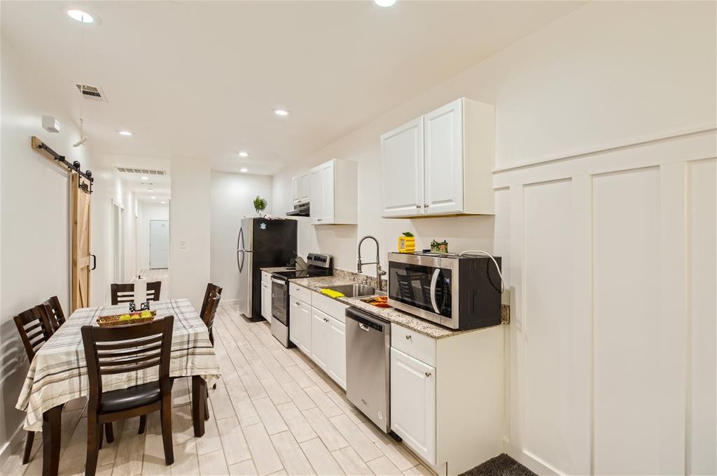 a kitchen with white cabinets and stainless steel appliances