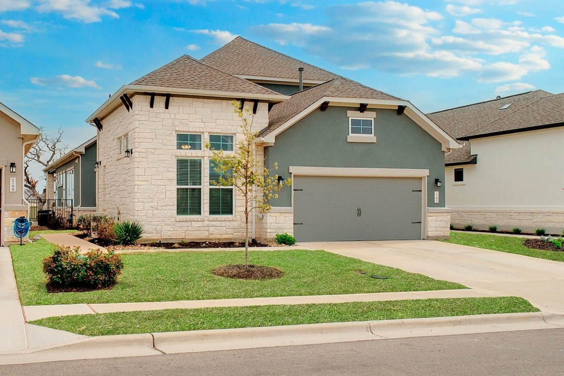 a front view of a house with a yard and garage