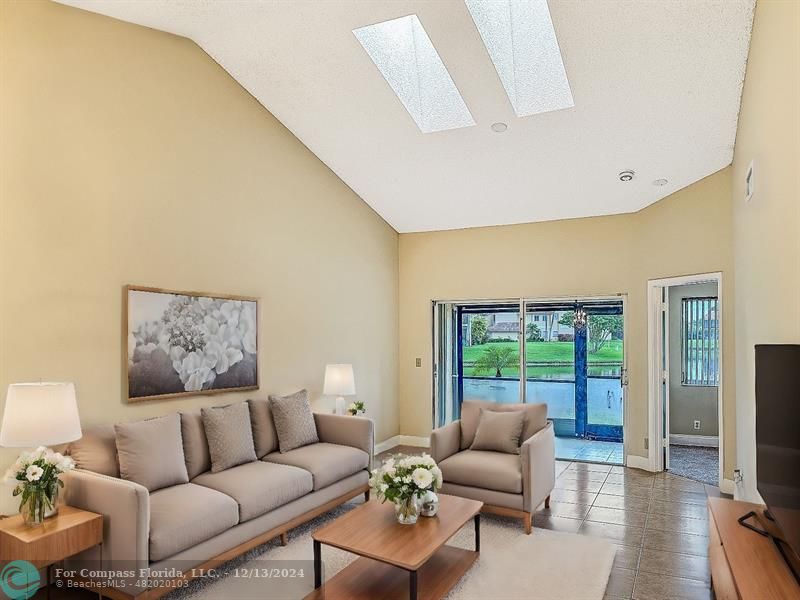 a living room with furniture a flat screen tv and a large window