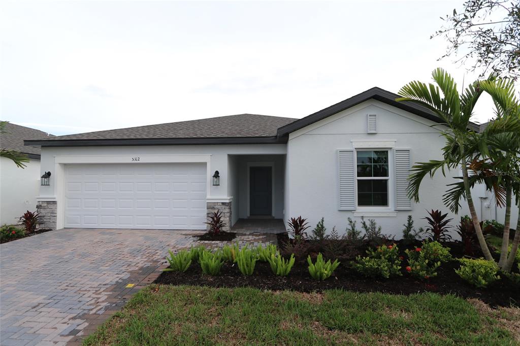 a front view of a house with a garden