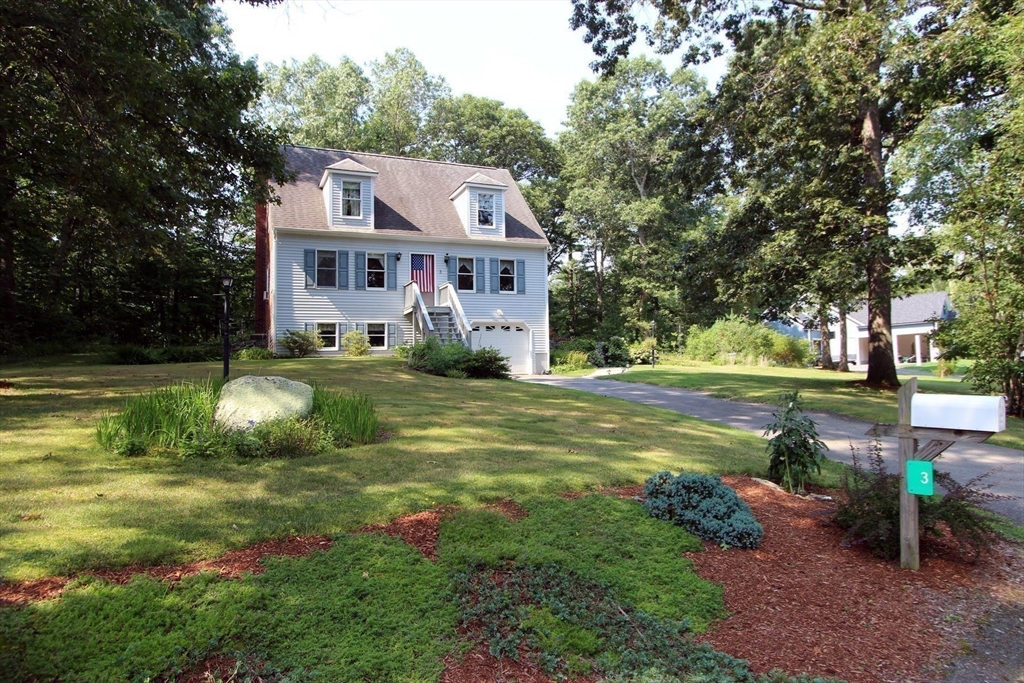 a view of a house with a big yard and large trees