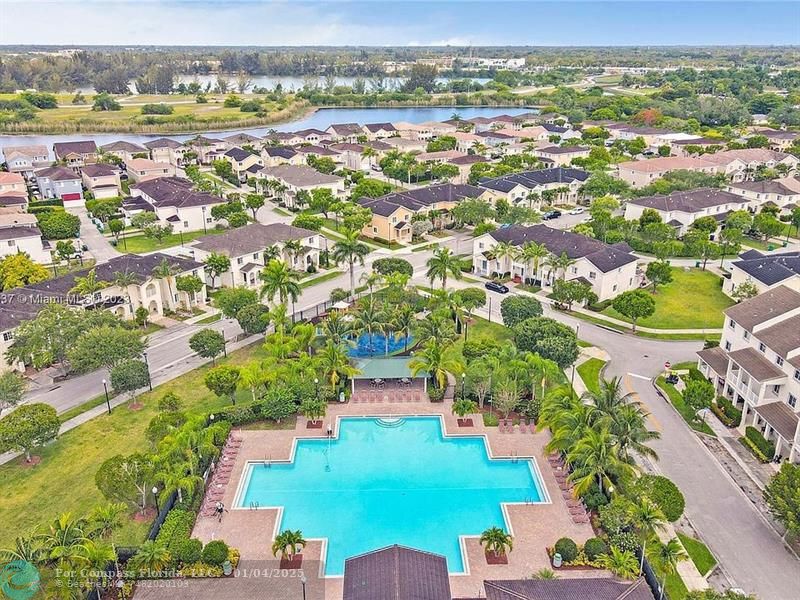 an aerial view of residential houses with outdoor space and parking