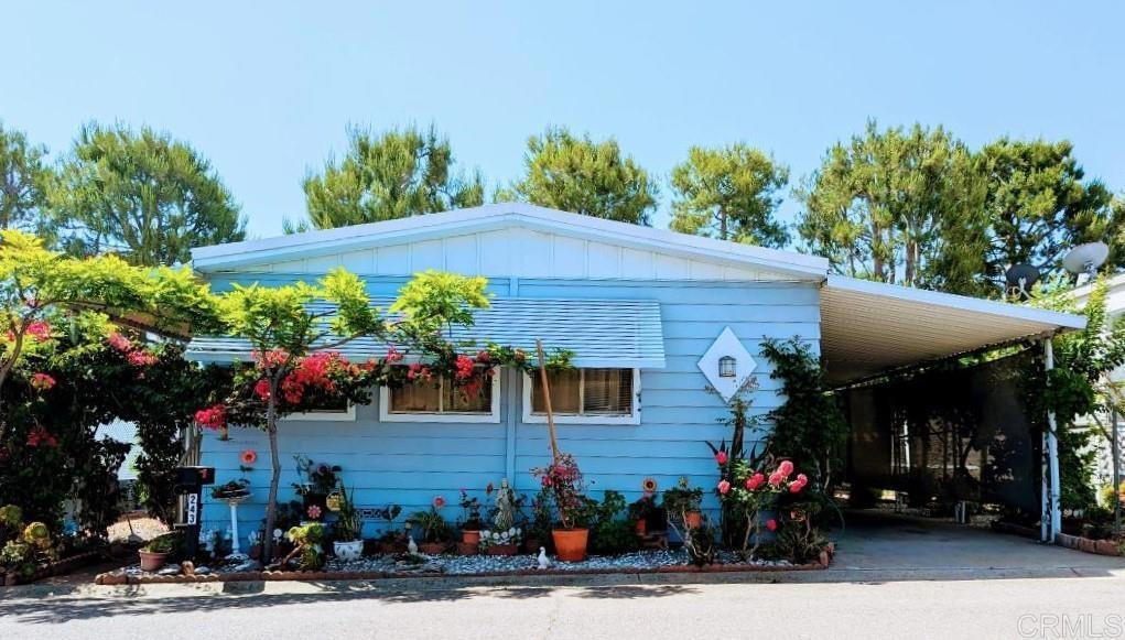 a front view of a house with a tree