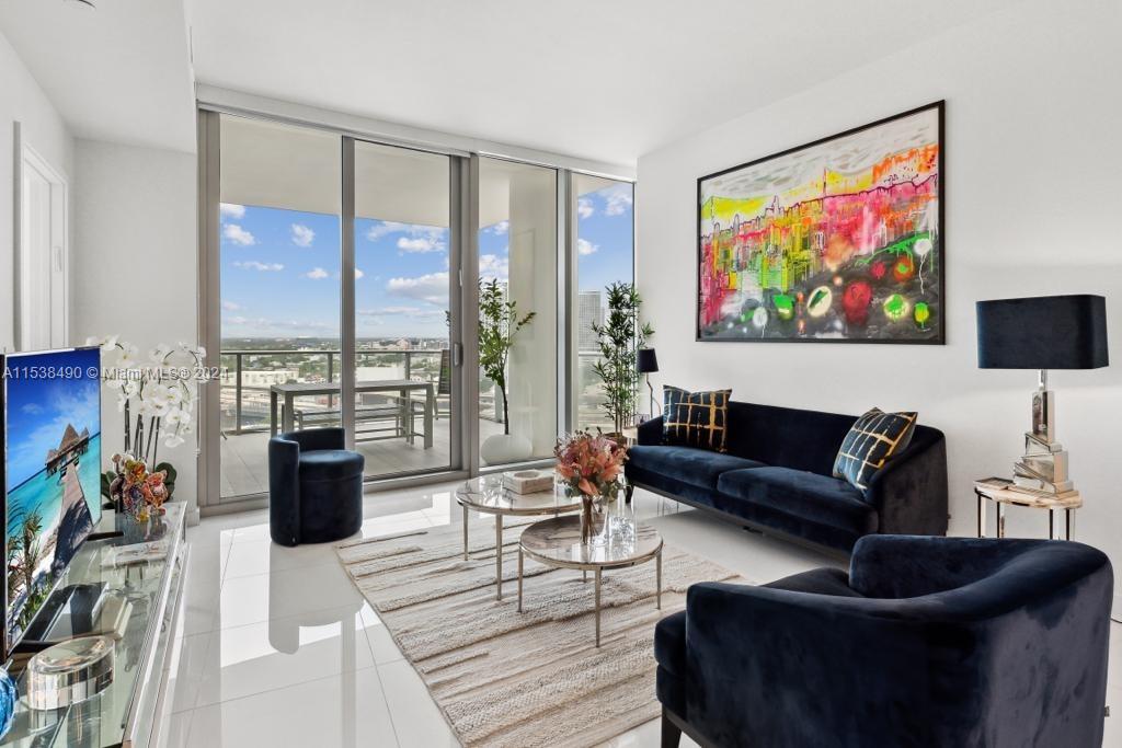 a living room with furniture large window and a flat screen tv