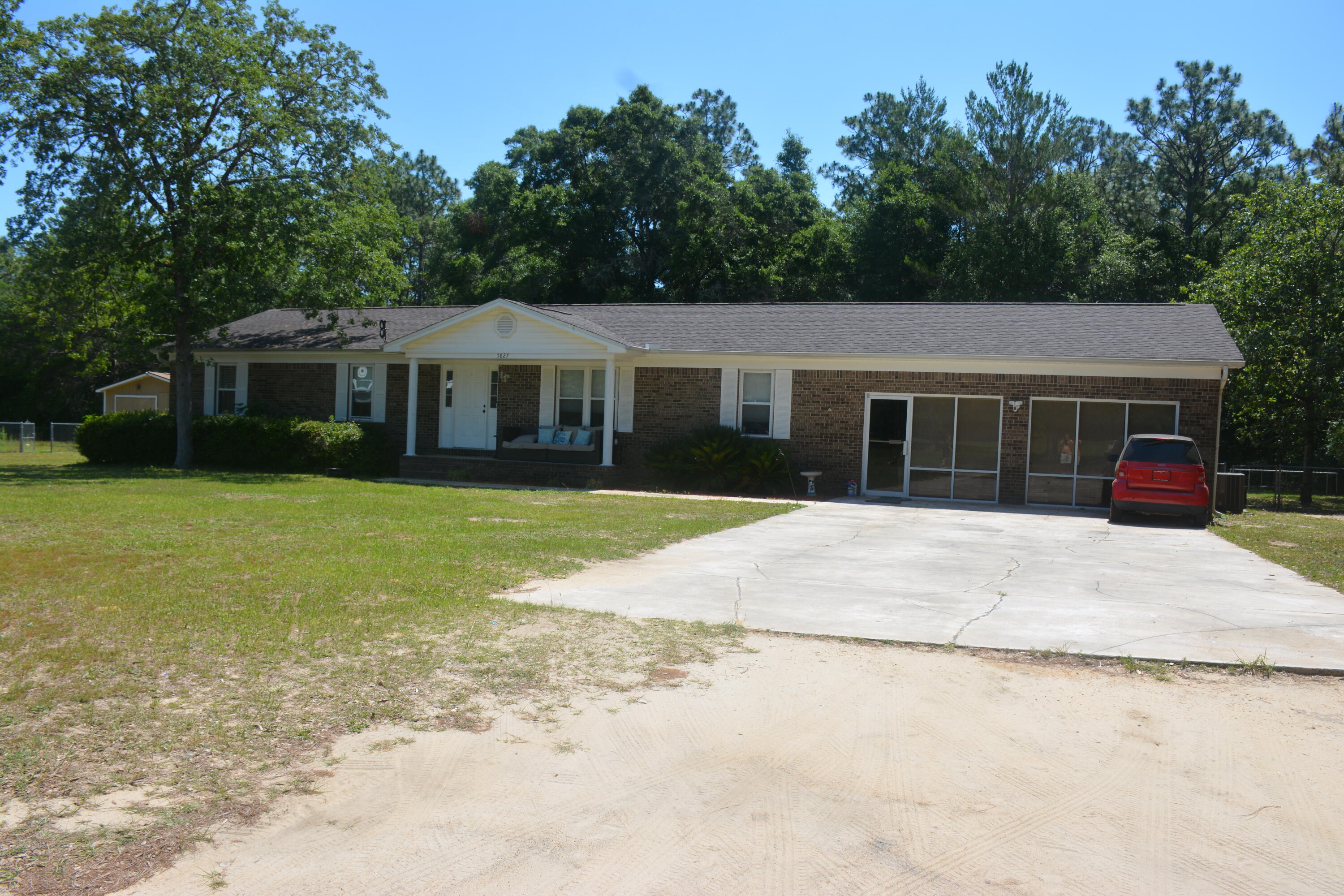 a front view of a house with a garden and trees