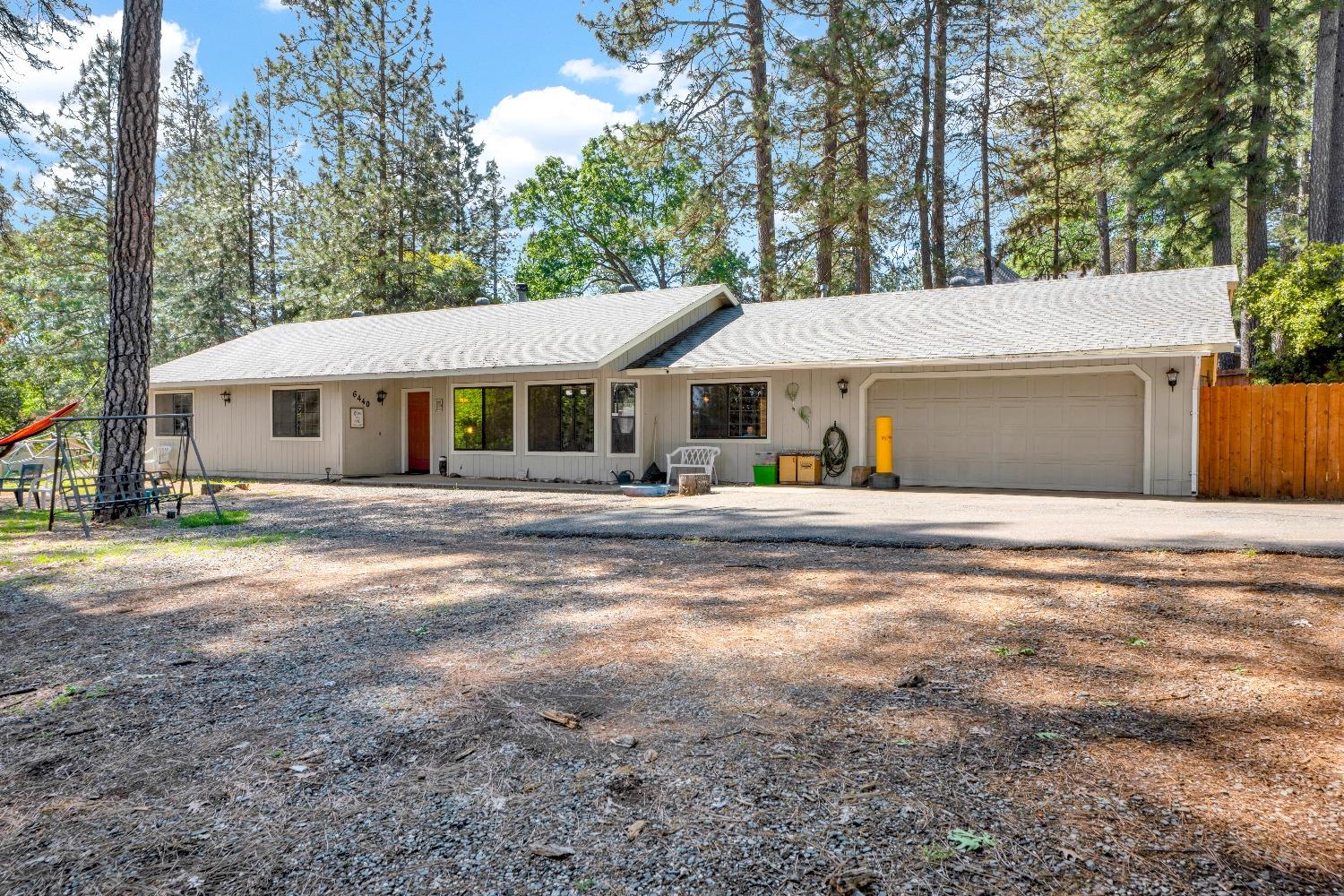 a front view of a house with a yard and trees